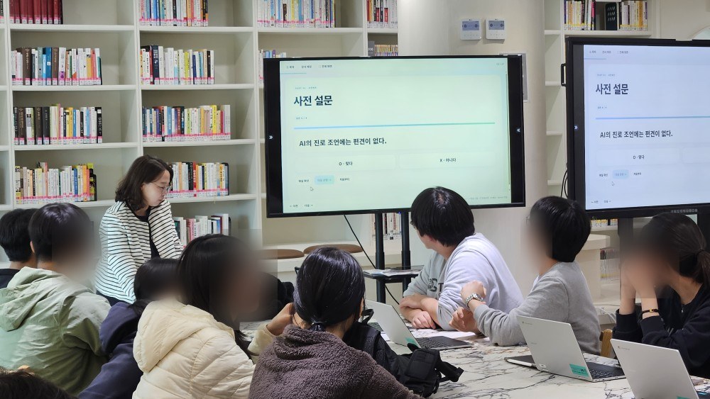 사전 설문 화면 'AI의 진로 조언에는 편견이 없다'를 보며 생각을 나누는 학생들과 강사